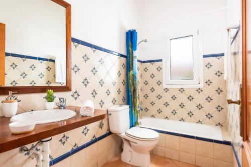 a bathroom with a toilet and a sink and a tub at Villa Ingrid Porter by Villa Plus in Cala'n Porter