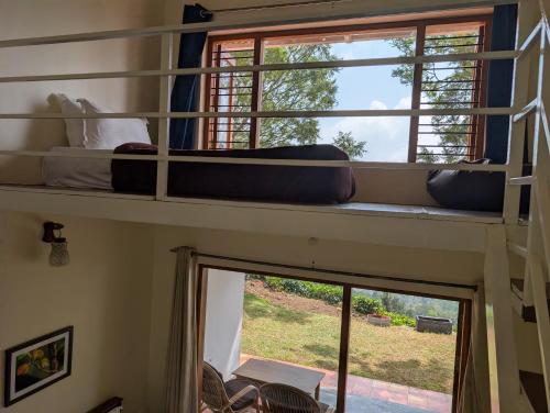 deux lits superposés dans une chambre avec fenêtre dans l'établissement Moksha at Infinity Valley, à Kotagiri