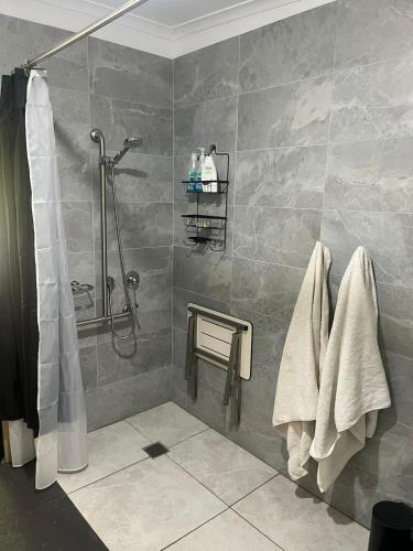 a bathroom with a shower and towels on a wall at Private Accommodation at the Megaranch in Nyora