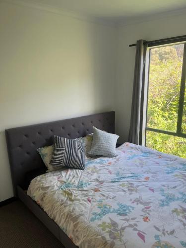 a bed with pillows on it with a window at Private Accommodation at the Megaranch in Nyora