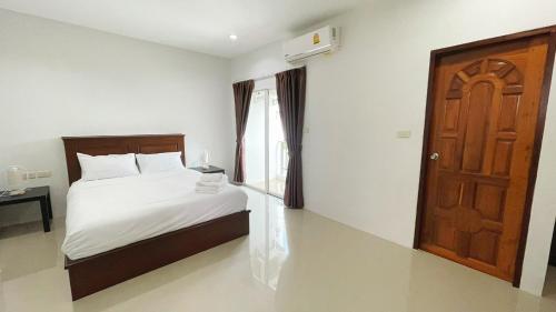 a bedroom with a bed and a wooden door at The Nap House Phuket Town in Phuket