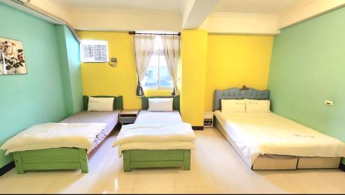 2 letti in una camera con pareti gialle e verdi di Mei Lun Xi Pan Homestay a Città di Hualien