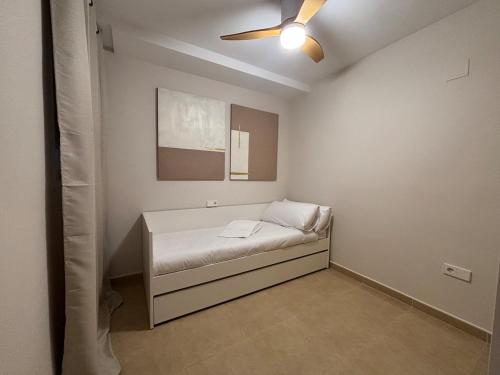a small bedroom with a bed and a ceiling fan at Cosy Flat Valencia in Masanasa