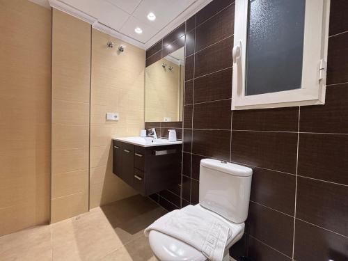 a bathroom with a toilet and a sink and a mirror at Cosy Flat Valencia in Masanasa