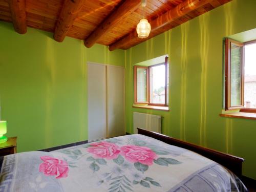 a bedroom with green walls and a bed with pink flowers at Gîte en Pierre avec Grand Terrain à Saint-Nizier-de-Fornas - FR-1-496-259 in Saint-Nizier-de-Fornas