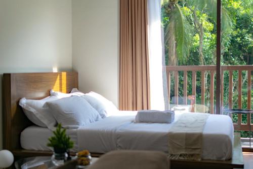 a bedroom with a bed and a large window at Alpine Haven at Alpine Villas by Crosswinds Tagaytay & Free Parking in Sampong