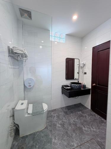 a bathroom with a toilet and a sink and a mirror at Dawn Garden Luangprabang Hotel in Luang Prabang