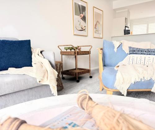 a living room with two chairs and a couch at Pacific Blue Poolside Escape - Oaks Port Stephens Pacific Blue Resort in Salamander Bay