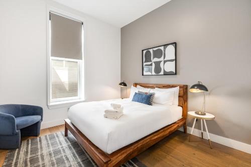 Un dormitorio con una cama y una silla azul. en The Saddlery - Headliner - Walk to Broadway, en Nashville