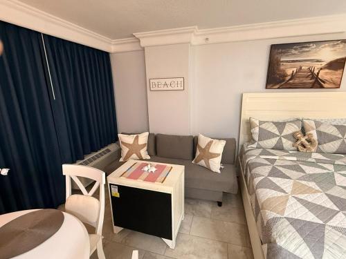 Un dormitorio pequeño con una cama y un sofá. en New Amazing Ocean View Beachfront Entire Apartment Direct access to Beach, en Daytona Beach