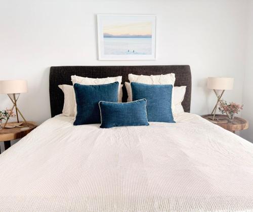 een slaapkamer met een groot bed met blauwe kussens bij One-Bedroom Lagoon Spa Apartment in Salamander Bay