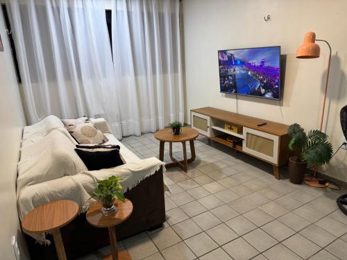 a living room with a couch and a flat screen tv at Apt 202B- 2 quartos climatizado em Ponta de Campina in Cabedelo