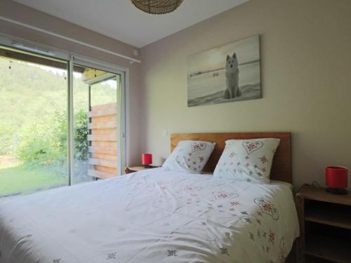 une chambre avec un lit blanc et une fenêtre dans l'établissement Appartement accessible PMR avec jardin et parking couvert, proche des pistes - FR-1-858-8, à Mont-Dore