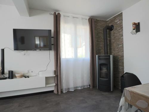 ein Wohnzimmer mit Kamin und Fernseher in der Unterkunft L'R du Roc : Appartement Duplex 4* avec Terrasse et Garage - FR-1-858-7 in La Bourboule