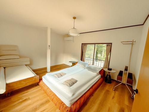 a bedroom with a large bed and a window at 雲の家 旧東海道沿いの畑宿の温もりステイ in Hakone