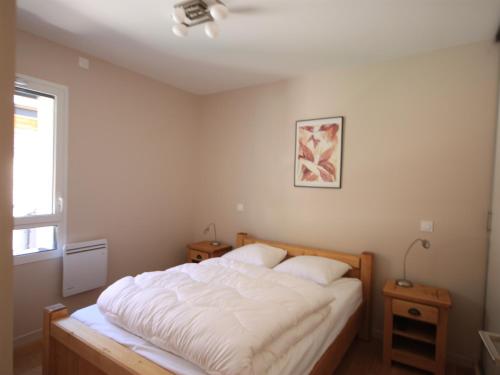 une chambre avec un grand lit blanc avec deux oreillers dans l'établissement Chalet Montagne avec Terrasse et Parking - FR-1-858-29, à Mont-Dore