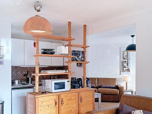 une cuisine avec un micro-ondes sur un meuble en bois dans l'établissement Studio confortable pour 6, au pied des pistes, Sud - FR-1-811-46, à Les Deux Alpes
