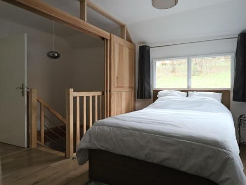 une chambre avec un grand lit et une fenêtre dans l'établissement Maison neuve 4* pour 6 personnes au Mont Dore avec terrasse - FR-1-858-5, à Mont-Dore