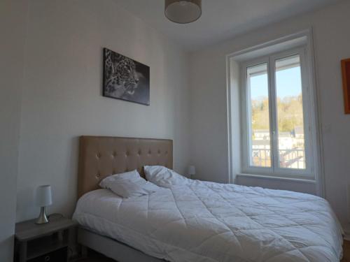 ein weißes Schlafzimmer mit einem Bett und einem Fenster in der Unterkunft Grande maison jusqu'à 8 personnes à La Bourboule - FR-1-858-6 in La Bourboule