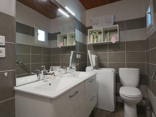 ein Badezimmer mit einem weißen Waschbecken und einer Toilette in der Unterkunft Maison 3* cosy au centre de La Bourboule pour 6 pers. - FR-1-858-13 in La Bourboule