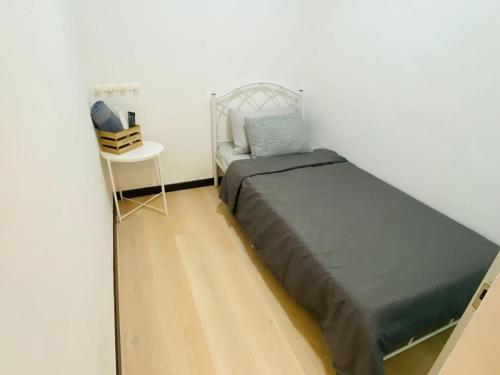 ein kleines Schlafzimmer mit einem Bett und einem Tisch in der Unterkunft Majestic Manhattan Suites ITCC in Penampang
