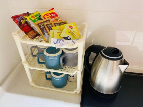 ein Kühlschrankfach mit Lebensmitteln und ein Wasserkocher in der Unterkunft Majestic Manhattan Suites ITCC in Penampang