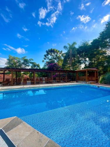 a swimming pool with a blue sky in the background at Espaço Tajj in São Roque