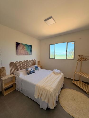 a bedroom with a large bed in a room with a window at Pousada Amarílis in Barra de Santo Antônio