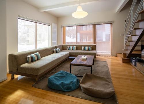 een woonkamer met een bank en een tafel bij Snow Fox in Kutchan