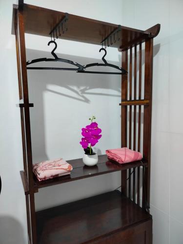 a shelf with a flower in a vase on it at Quarto 2 camas de Solteiro in Belém