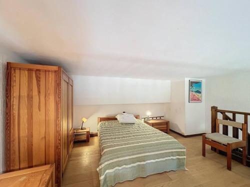 a bedroom with a bed and a chair at Appartement avec jardin en bord de mer, climatisation et Wifi - FR-1-770-64 in Les Lecques