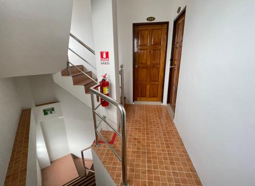 a hallway with a staircase with a door and a fire hydrant at The Nap House Phuket Town in Phuket