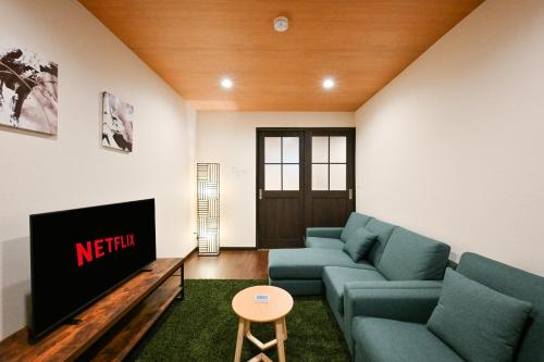 a living room with a couch and a tv at Seed INN Iori-庵- in Tokyo