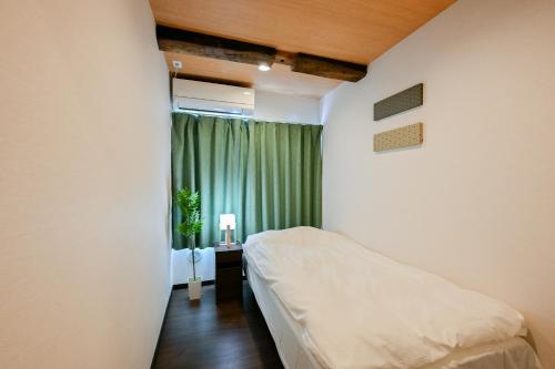 a small bedroom with a bed and a window at Seed INN Iori-庵- in Tokyo