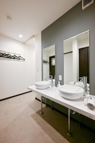 two sinks in a bathroom with two mirrors at Seed INN Iori-庵- in Tokyo