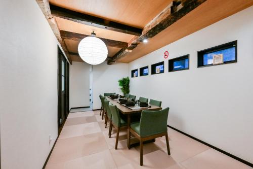 a dining room with a table and green chairs at Seed INN Iori-庵- in Tokyo