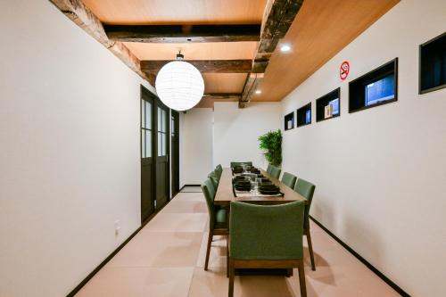 a dining room with a table and green chairs at Seed INN Iori-庵- in Tokyo