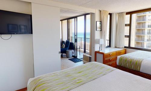 Postel nebo postele na pokoji v ubytování Waikiki Banyan Plumeria Suite