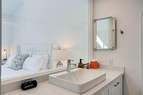 a white bathroom with a sink and a mirror at Beachfront Hideaway in Santa Barbara