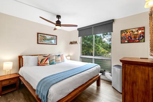 Un dormitorio con una cama y una ventana en Kalama Terrace 2BR with Pool, BBQ, AC & Walk to the Beach, en Kihei