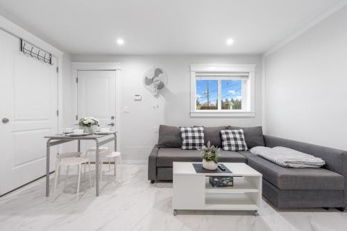 a living room with a couch and a table at Cozy and Modern 2br guesthouse in Vancouver