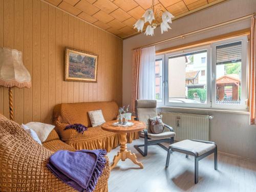 a living room with a table and a chair at Ferienwohnung in der Nähe des Brockengipfels in Ilsenburg