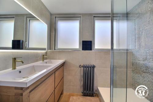 ein Badezimmer mit Waschbecken und Glasdusche in der Unterkunft De lescuillo in Noyal-Muzillac