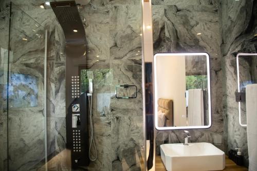 a bathroom with a sink and a shower with a mirror at Sea Bloom Villa in Kamburugamuwa