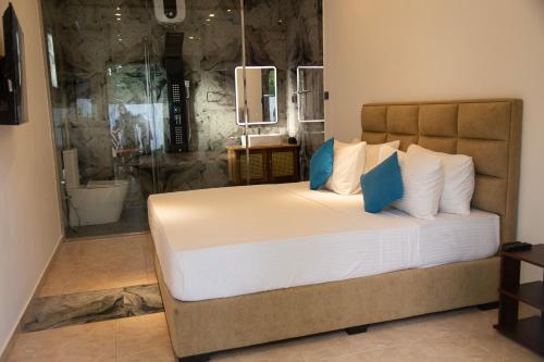 a bedroom with a large bed and a shower at Sea Bloom Villa in Kamburugamuwa