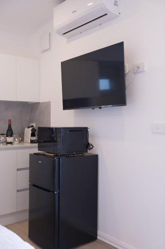 a kitchen with a black refrigerator and a flat screen tv at Modern room in Williamstown in Williamstown