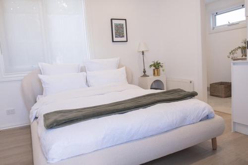 - une chambre blanche avec un grand lit blanc et des oreillers blancs dans l'établissement Modern room in Williamstown, à Williamstown