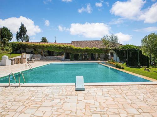 a swimming pool in front of a house at Wine Country Home in Alentejo in Montemor-o-Novo