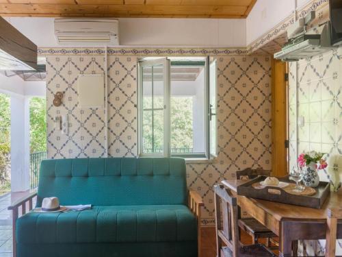 a living room with a green couch and a table at Wine Country Home in Alentejo in Montemor-o-Novo
