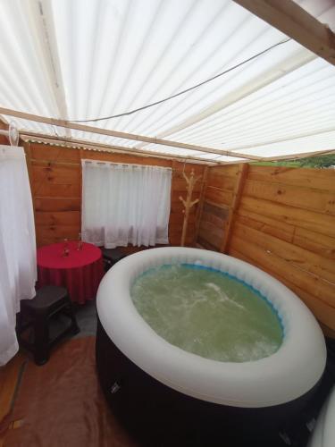 a large bath tub in a tent with a table at Cabaña La Granja tomine in Guatavita